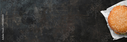 Billede på lærred Big hamburger on a grunge backround  - banner / backround