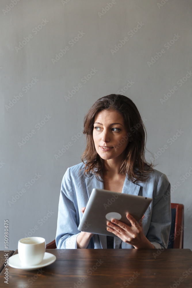 Amazing woman sitting indoors using tablet computer. Amazing woman sitting indoors using tablet computer.