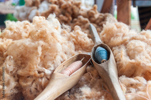 A close up image of an old weaving Loom and thread of yarn. 