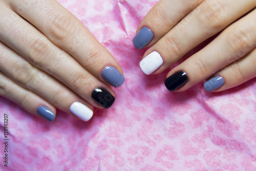 Black, grey and white polished nails on pink background