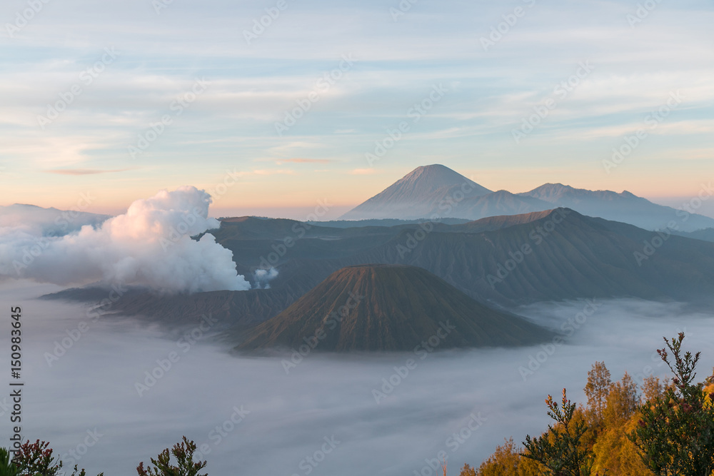Volcanic smoke over Mountain Bromo and surround by fog in the early morning at Bromo tengger semeru national park, East Java, Indonesia