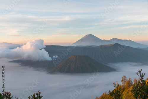Volcanic smoke over Mountain Bromo and surround by fog in the early morning at Bromo tengger semeru national park, East Java, Indonesia
