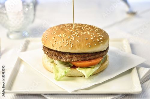 Tasty burger grilled beef tomato and lettuce on a white plate