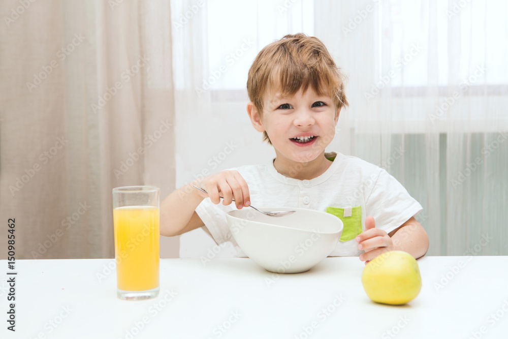 Little boy having breakfast in the kitchen. Little boy having breakfast in the kitchen.