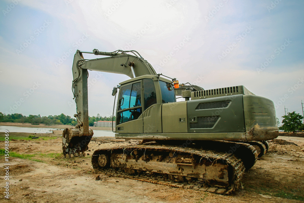 Fototapeta premium Excavator or backhoe at the construction site with Pale sky