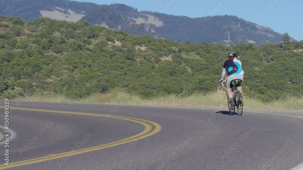 Man riding bicycle on country road Man riding bicycle on country road