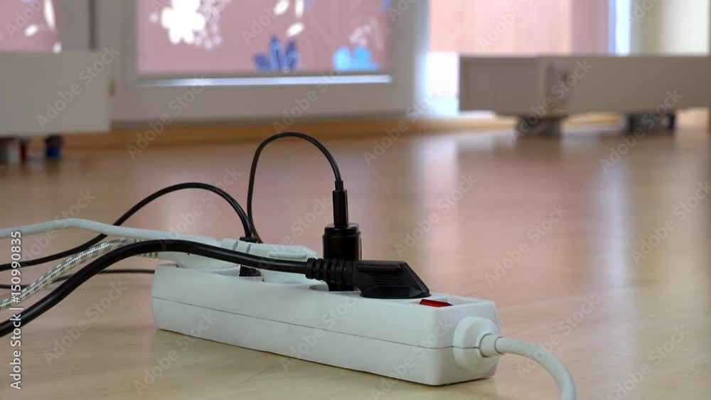 Hand pay euro banknote for high electricity usage in front of switch with plugs Hand pay euro banknote for high electricity usage in front of switch with plugs