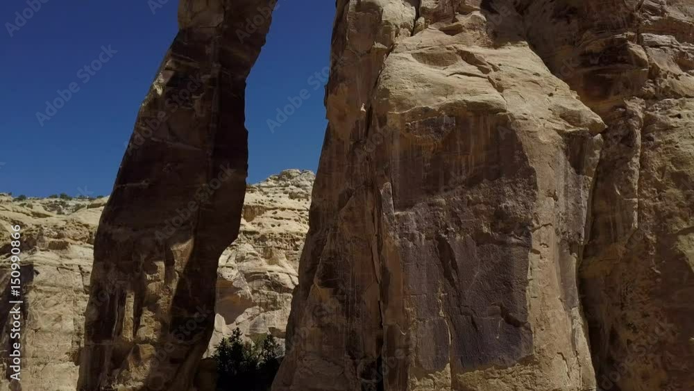 Aerial Eagle Arch San Rafael Utah slide away reveal. Overhead drone view. Geologic landscape. Dangerous wilderness desert environment.