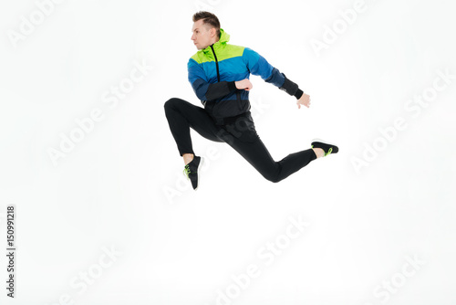 Strong sportsman jumping isolated over white background