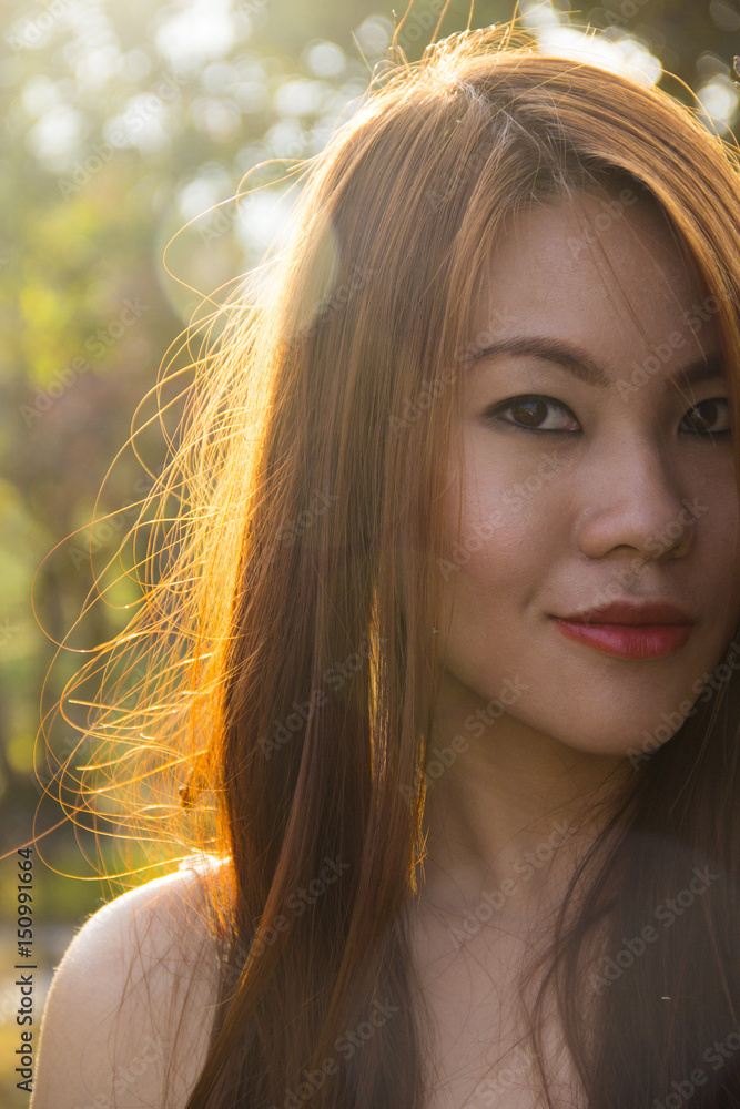 Asian girl in a field, backlit by the sun Asian girl in a field, backlit by the sun