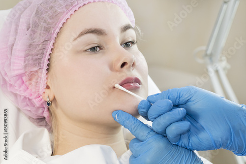 The process of cosmetic surgery of water injection in the area of the lips of a woman   