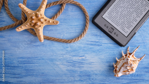 Summer sea vacation mockup background. Travel and vacation items on blue wooden table. Seashells. eBook. Knot.