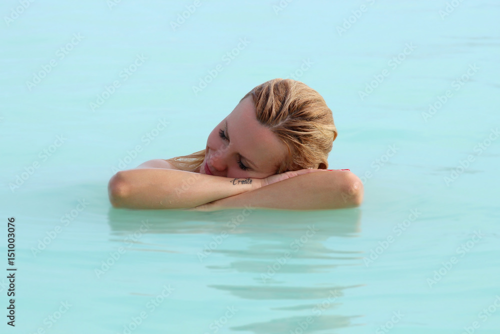A woman enjoys spa in hot spring Blue Lagoon in Iceland A woman enjoys spa in hot spring Blue Lagoon in Iceland