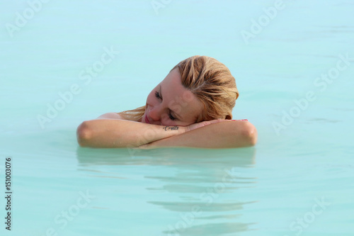 A woman enjoys spa in hot spring Blue Lagoon in Iceland