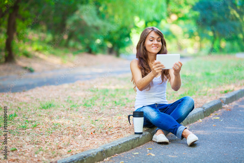 Girl sitting with a tablet in hands Girl sitting with a tablet in hands