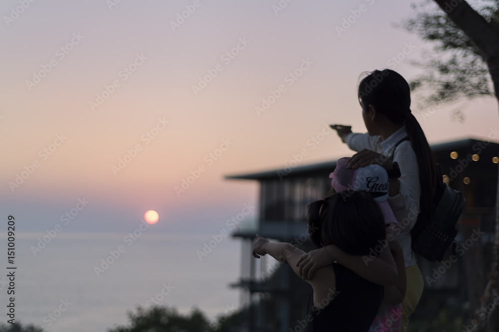 Obraz premium Family of three person is standing on sunset