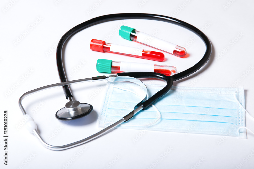 Test tubes with blood test and stethoscope on white background Test tubes with blood test and stethoscope on white background