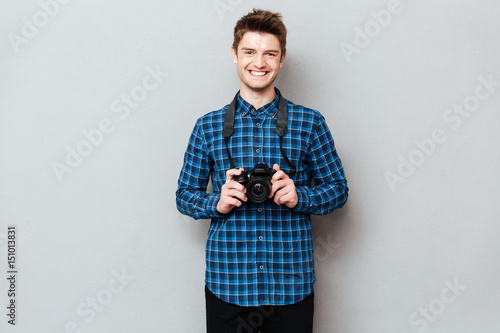 Cheerful man with camera posing isolated