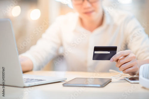 Man hand holding credit card, see the security code and using laptop computer for online shopping and online payment, modern lifestyle with digital transaction concepts