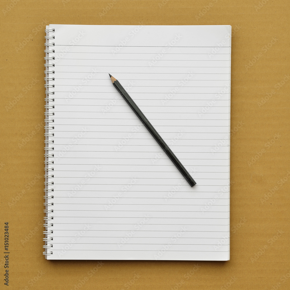 Notebook with pencil on cardboard background. Notebook with pencil on cardboard background.