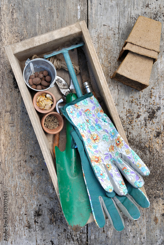 gants et accessoires de jardinage dans boîte sur planche en bois