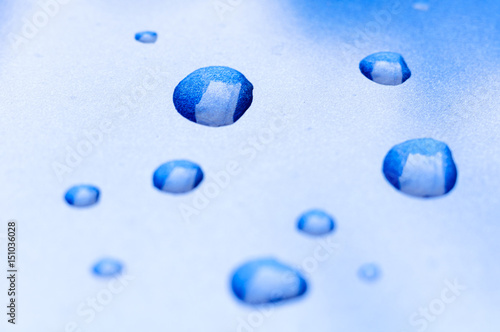 Water drops on gradient of twinkling blue and white background surface or texture