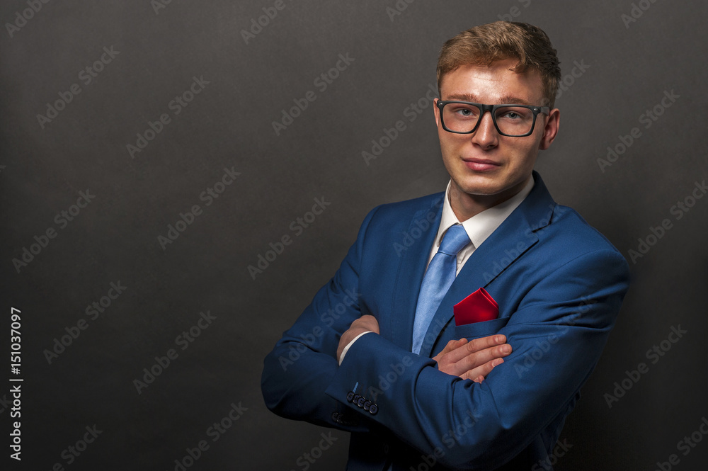 Young handsome man in black suit smiling on dark background Young handsome man in black suit smiling on dark background