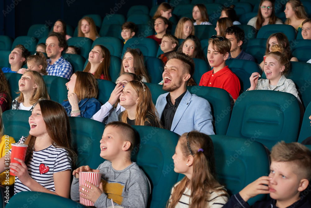 Happy little kids laughing watching a comedy movie at the local cinema people exciting amazing emotional expressive funny positivity leisure hobby lifestyle concept.