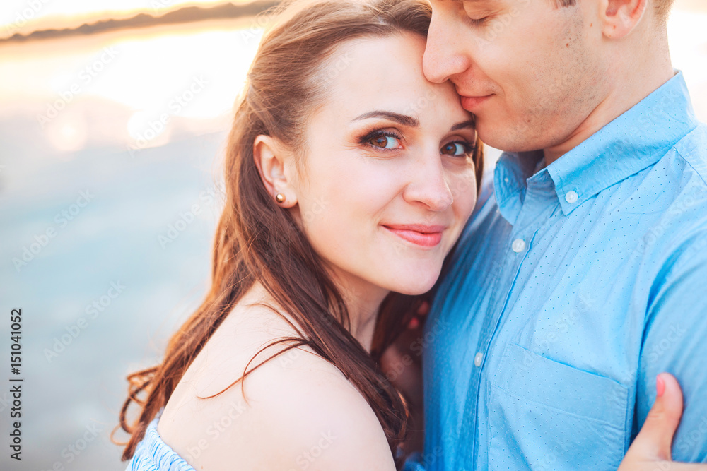 Young couple in love hug each other at the lake outdoor in summer day, harmony concept Young couple in love hug each other at the lake outdoor in summer day, harmony concept