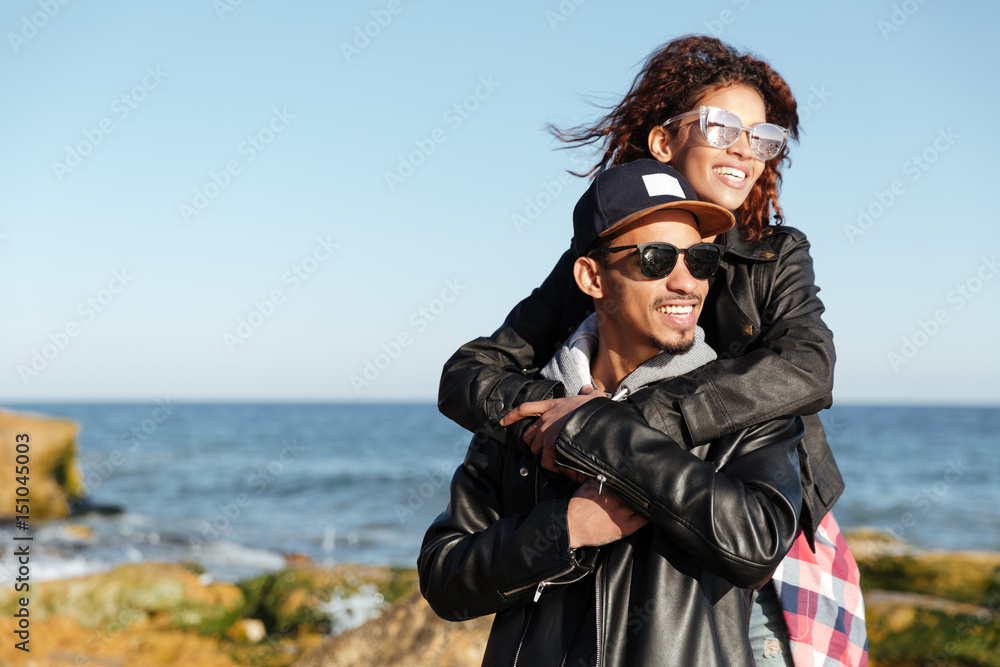 Smiling african loving couple walking outdoors at beach