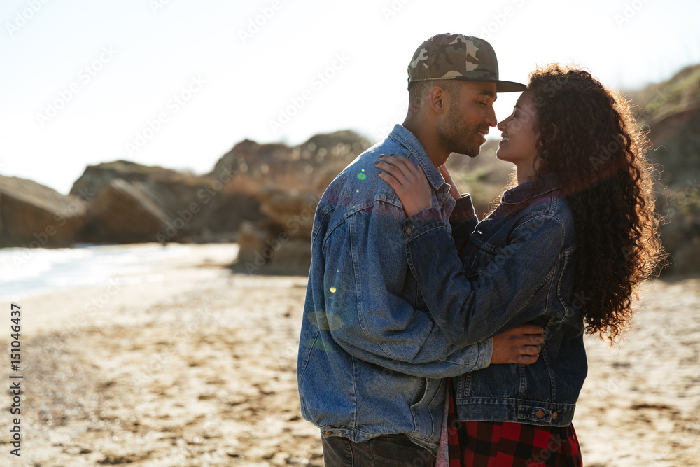 Happy african loving couple hugging outdoors at beach Happy african loving couple hugging outdoors at beach