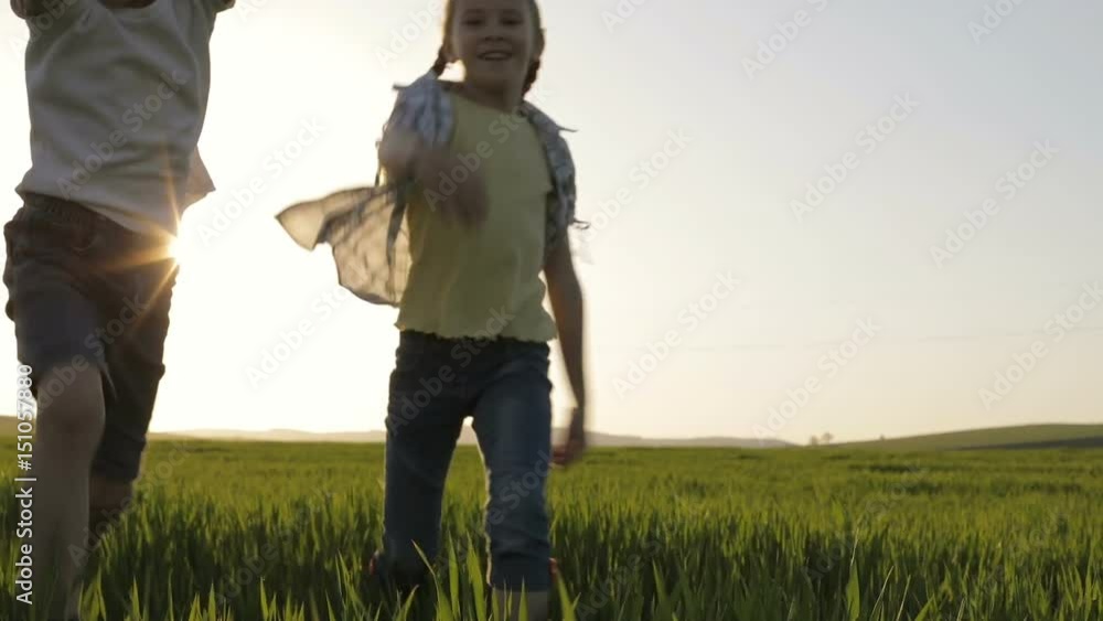 Two happy children playing in the field at the day time. Kid having fun outdoors. Concept of happy game. Two happy children playing in the field at the day time. Kid having fun outdoors. Concept of happy game.
