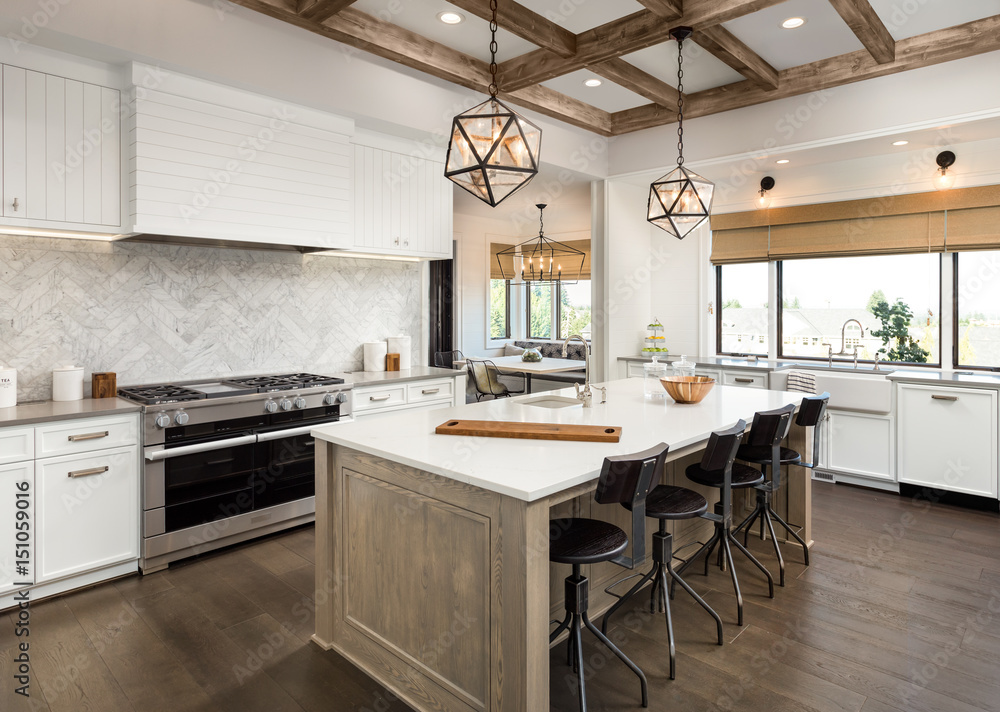 Fototapeta premium Beautiful Kitchen in New Luxury Home with Island, Cross Hatch Wood Beams on Ceiling, Hardwood Floors, Farmhouse Sink, and Elegant Pendant Lights