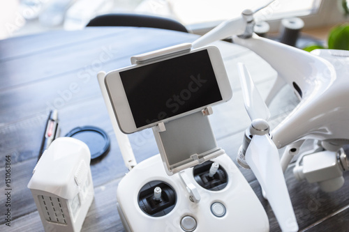 Drone with a control panel on the background of a dark wooden table. Aerial shooting concept. Before flight training. Top view. Outfit before the flight.