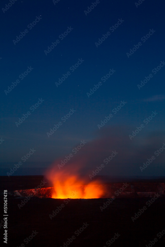 Ein Lavasee im  Halemaumau Krater auf dem Kilauea beleuchtet aufsteigende vulkanische Dämpfe vor dem Nachthimmel im Hawaii Volcanoes National Park auf Big Island, Hawaii, USA.
