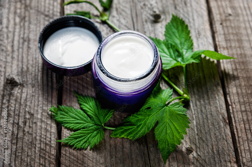 Jar of moisturizing facial cream with leaves