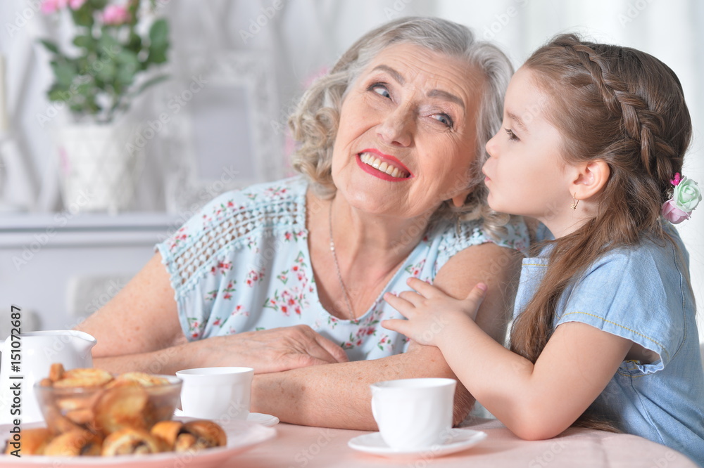 grandmother with a small granddaughter drinking tea grandmother with a small granddaughter drinking tea