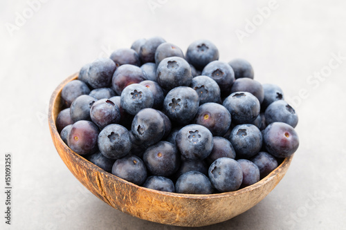 Fresh blueberries natural coconut in a bowl on a gray background.