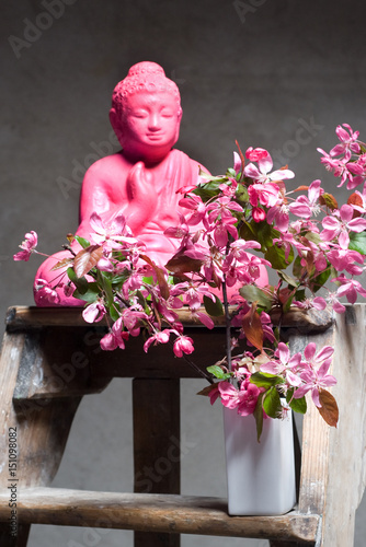 Kirschblueten und Buddhafigur auf Holzleiter photo