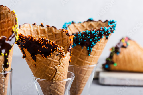 Bilde på lerret Chocolate dipped ice cream cones with sprinkles decorations