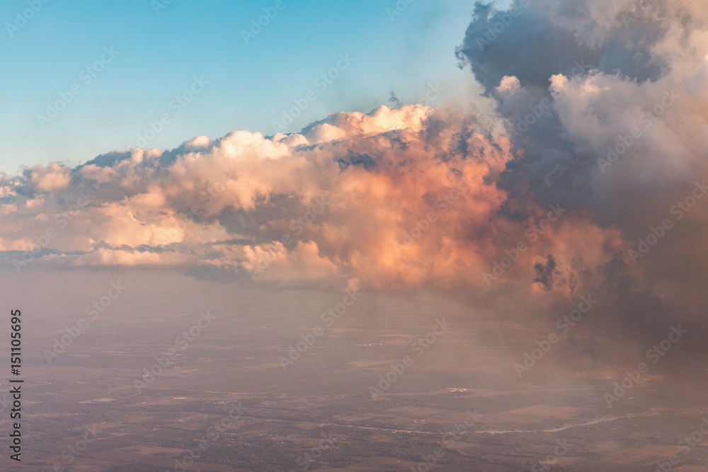 Aerial view of golden clouds lit by the evening sun over Florida, view from the aircraft during the flight.
