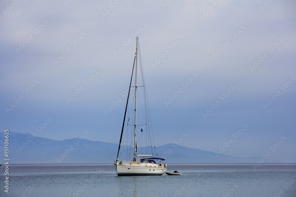 Sailing boat on a blue sea background