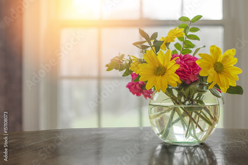Slika na platnu Spring flowers on table in vase with dark greys and blacks with open window fresh concept and copyspace