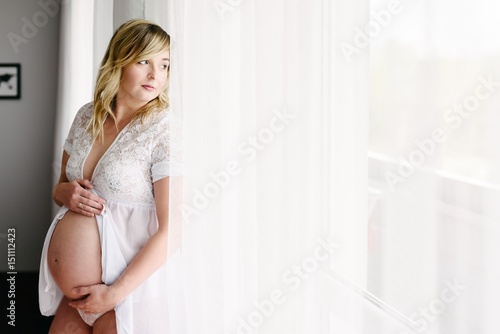 Future mum - pregnant woman standing by the window