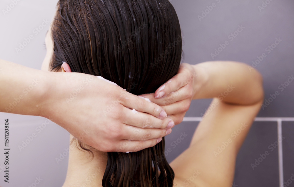 Fototapeta premium Woman applying hair conditioner.