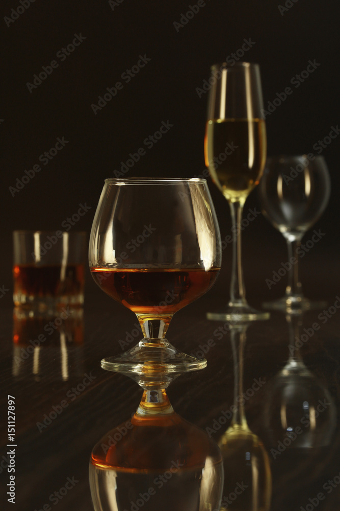 Glass with white, red wine and cognac or whisky on mirror table. Celebrities composition. selective focus Glass with white, red wine and cognac or whisky on mirror table. Celebrities composition. selective focus