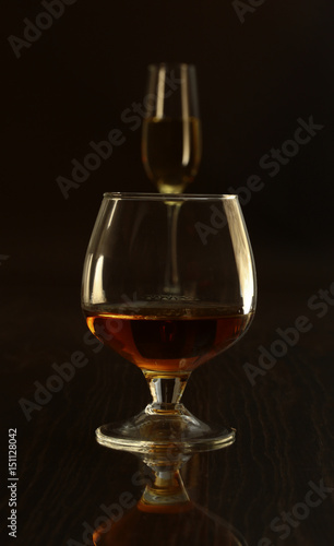 Glass with white, red wine and cognac or whisky on mirror table. Celebrities composition. selective focus