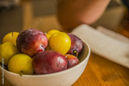 Ripe plums on wood table