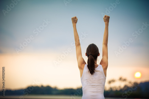 Strong and confident girl. Successful woman with her arms up in the air in celebration. 