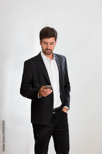 Young man is tlooking on his phone photo